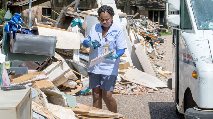 Baton Rouge, LA, Letter Carrier Bezeit Miles delivers mail following an August flood.