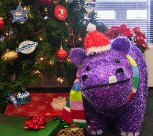The Christmas tree in Chief Operating Officer David Williams’ office emphasizes the #PostalProud initiative and is accompanied by a purple hippopotamus, similar to the one featured in this year’s holiday TV campaign.