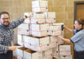 Customer Services Supervisor Joe Rann and Chelsea Winters, a postal support employee, arrange Priority Mail boxes into a festive formation at the Lansing, MI, Main Post Office.