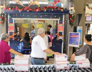 Customers line up for service at Rudolph’s Express Shipping Shack, a festive station at the Honolulu Main Post Office.