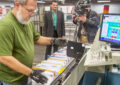 A TV news crew records Clerk Dale Dick working at the Madison, WI, Processing and Distribution Center.