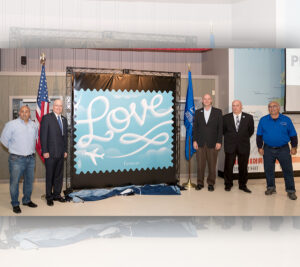 Present at the stamp unveiling are, from left, Stephen Stinis, president of Skytypers; Williams; Chris Clark, vice president and chief operating officer of Operation Gratitude, a group that sends care packages to armed forces personnel; Kevin Thompson, a Planes of Fame Air Museum aviation historian; and Greg Stinis.