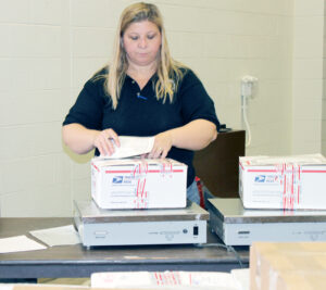 Saginaw, MI, Postmaster Carrier Downing prepares care packages recently.