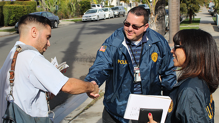 San Diego, CA, Letter Carrier Julio Mendroza is greeted recently by postal inspectors Patricia Mendoza and Cory Blott.