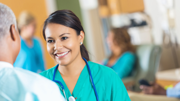 Female doctor smiles talking to male patient