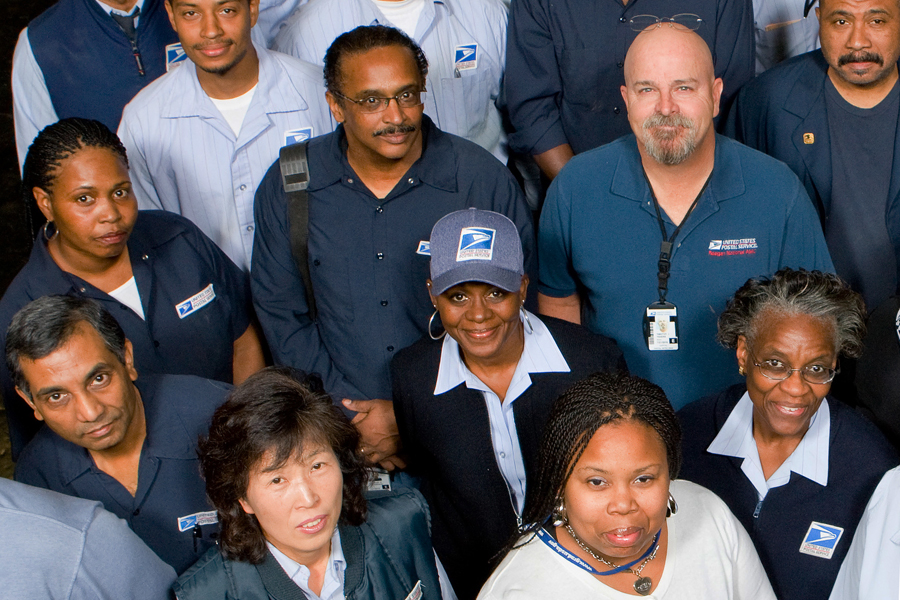 USPS employees pose in uniform