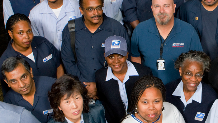 USPS employees pose in uniform