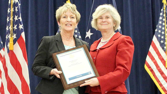 Greensboro District Retail Marketing Manager Tammy Apple receives an award from Michele Thoren