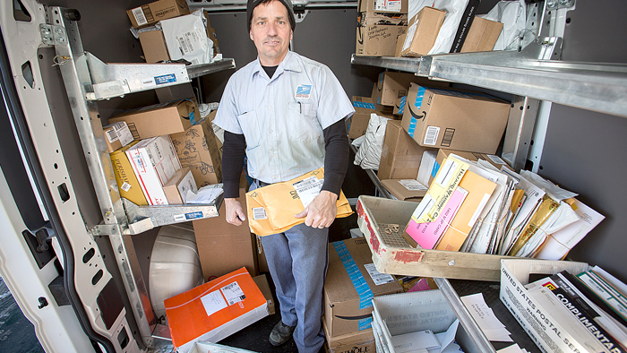 Madison, WI, Letter Carrier Tom Lukas sorts mail and packages