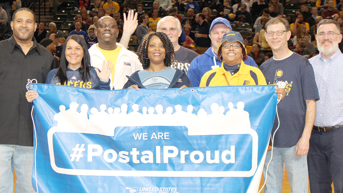 Greater Indiana District employee hold blue #PostalProud banner