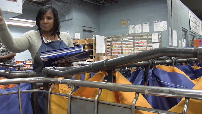 USPS employee sorts packages