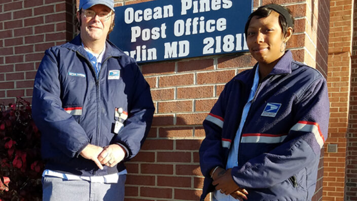 Two carriers in uniform stand in front of PO