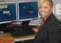 Woman sits and smiles at computer