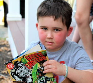 Devin reads a comic book collection donated by one of the postal employees.