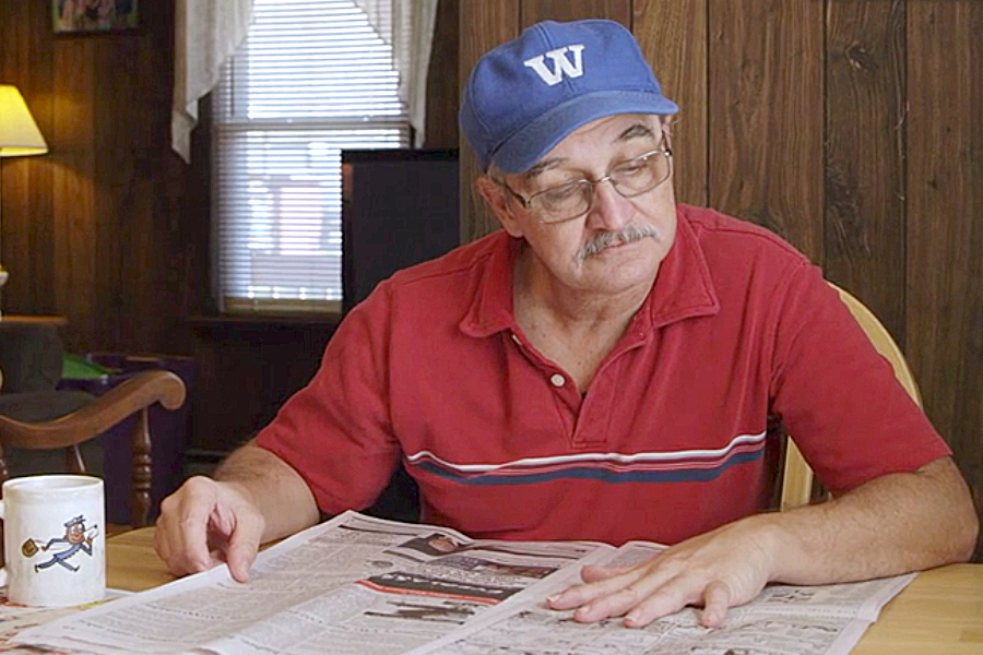 Man reads newspaper at home