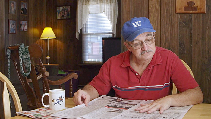 Man reads newspaper at home