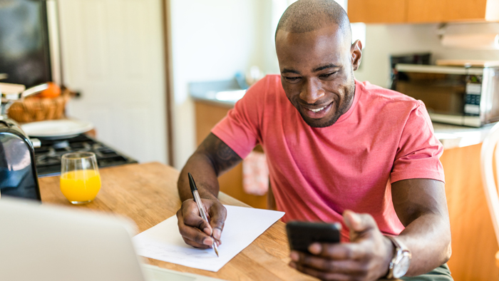 Man in red shirt looks at phone