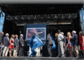 Participants gather on stage to unveil the stamp image.