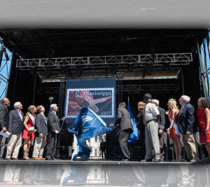 Participants gather on stage to unveil the stamp image.