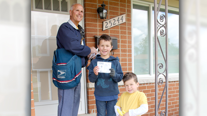 Letter carrier posed with two boy kids