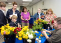 Attendees at the dedication ceremony observe a flower arranging demonstration.