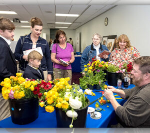 Attendees at the dedication ceremony observe a flower arranging demonstration.