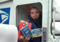 Male carrier holds donations while seated in truck