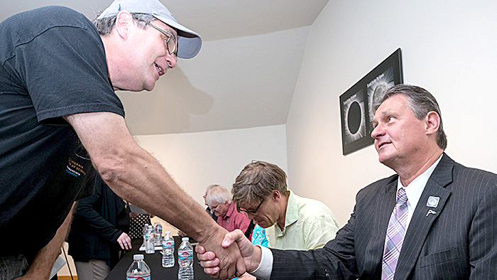 Chief Marketing and Customer Experience Officer Jim Cochrane greets an attendee