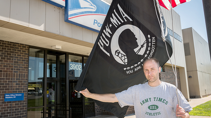 Kyle Indra prepares to raise the POW-MIA flag