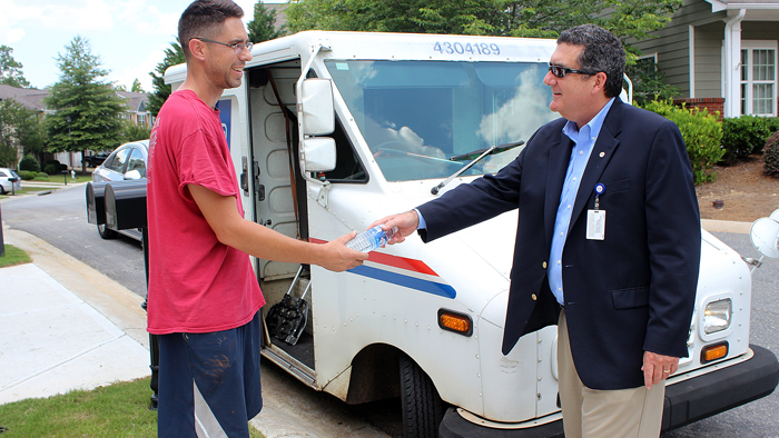 Rural Carrier Jabari Rayreceives a water bottle