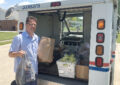 USPS employee lifting bag of food