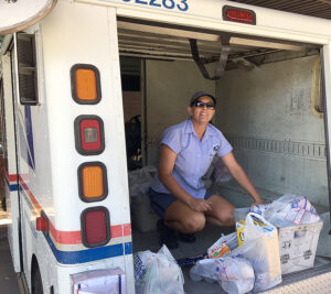 USPS employee loading food drive donations on vehicle