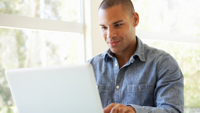 Smiling man using laptop