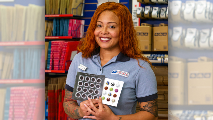 Employee poses with stamps