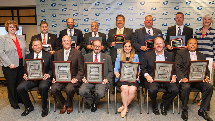 Two rows of winners hold plaques