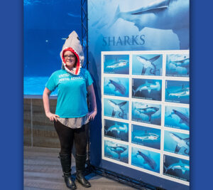 USPS employee stands near Sharks stamp display