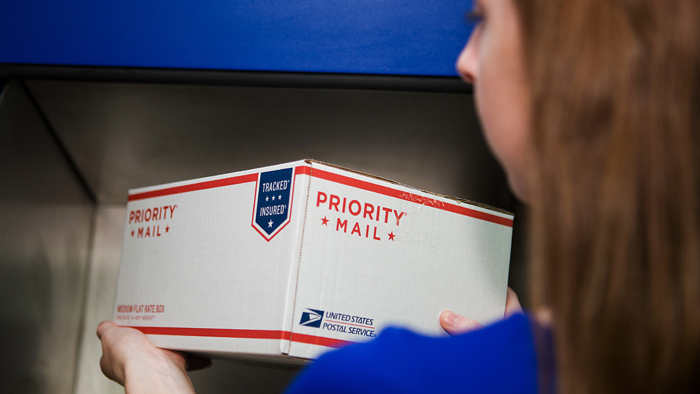 Woman holding Priority Mail box