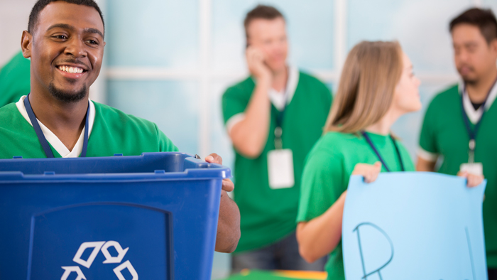 Employees in green shirts recycling