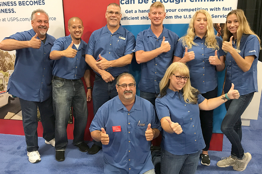 Employees pose in blue shirts