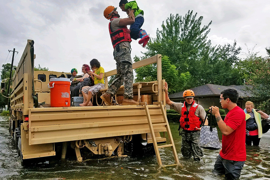 Soldier picks up child in flooded area