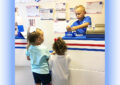 Two girls buy stamps from a boy in blue