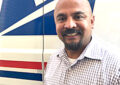 Man smiles by postal truck