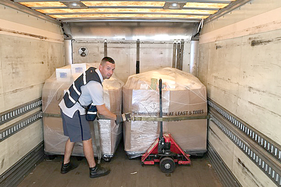 USPS employee loads cargo onto plane