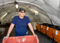 Man stands in front of mail cart