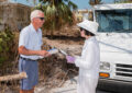 Letter carrier hands mail to woman