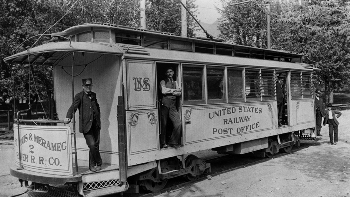 Black and white photo of men with trolley