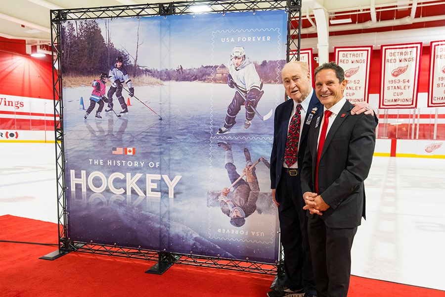 Red Kelly and Dr. Murray Howe stand near stamp display