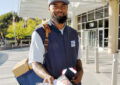 Male letter carrier on sidewalk