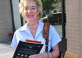 Female letter carrier on sidewalk