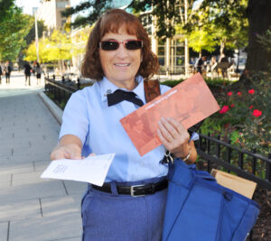 Female letter carrier on sidewalk